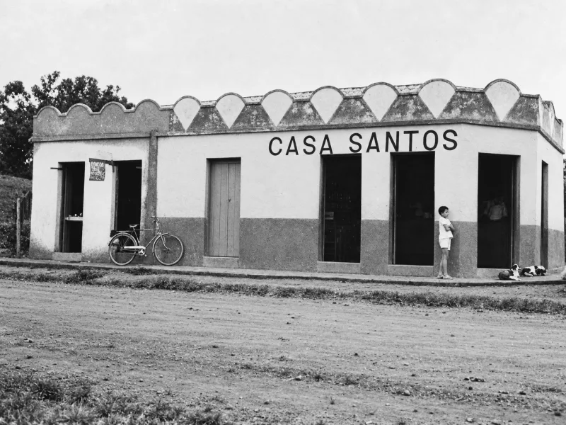 Fachada da Casa Santos, construção de esquina com frontão recortado e bicicleta encostada.