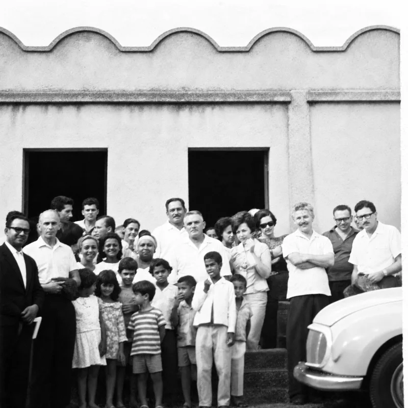 Grupo numeroso reunido diante da Casa Santos, com um automóvel antigo à direita.